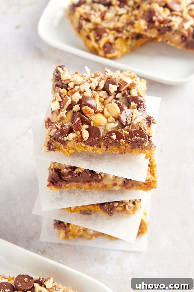 Stack of 4 seven layer bars with parchment paper between each, beautifully presented