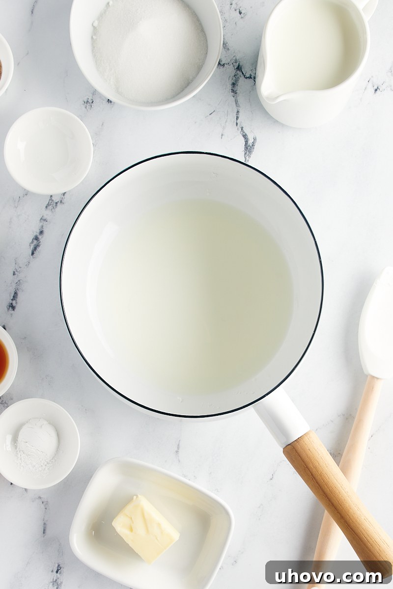 A saucepan containing a small amount of milk and cornstarch being whisked together, ensuring no lumps.