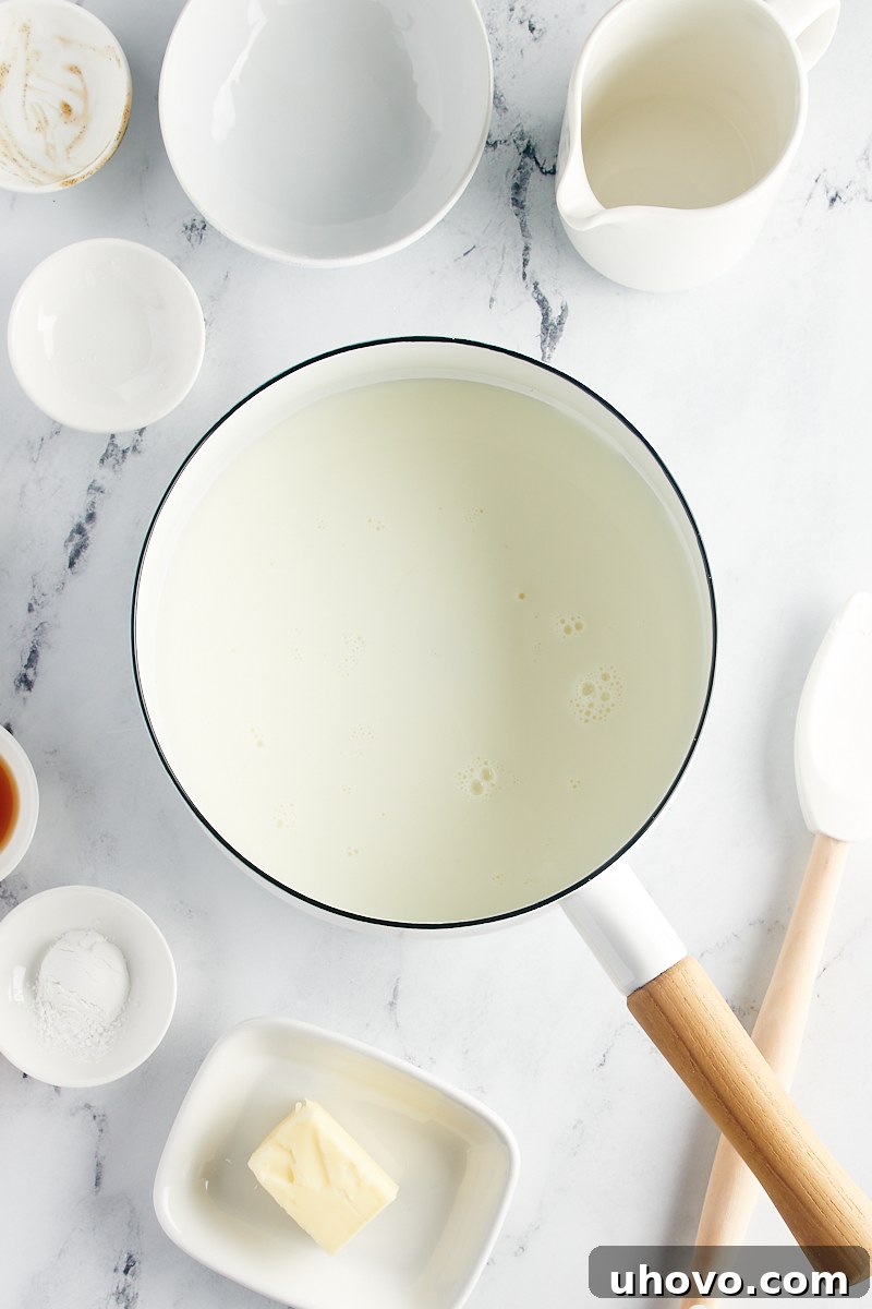 All the sauce ingredients—milk, sugar, cornstarch, vanilla bean paste, and salt—are combined in a saucepan, ready for heating.