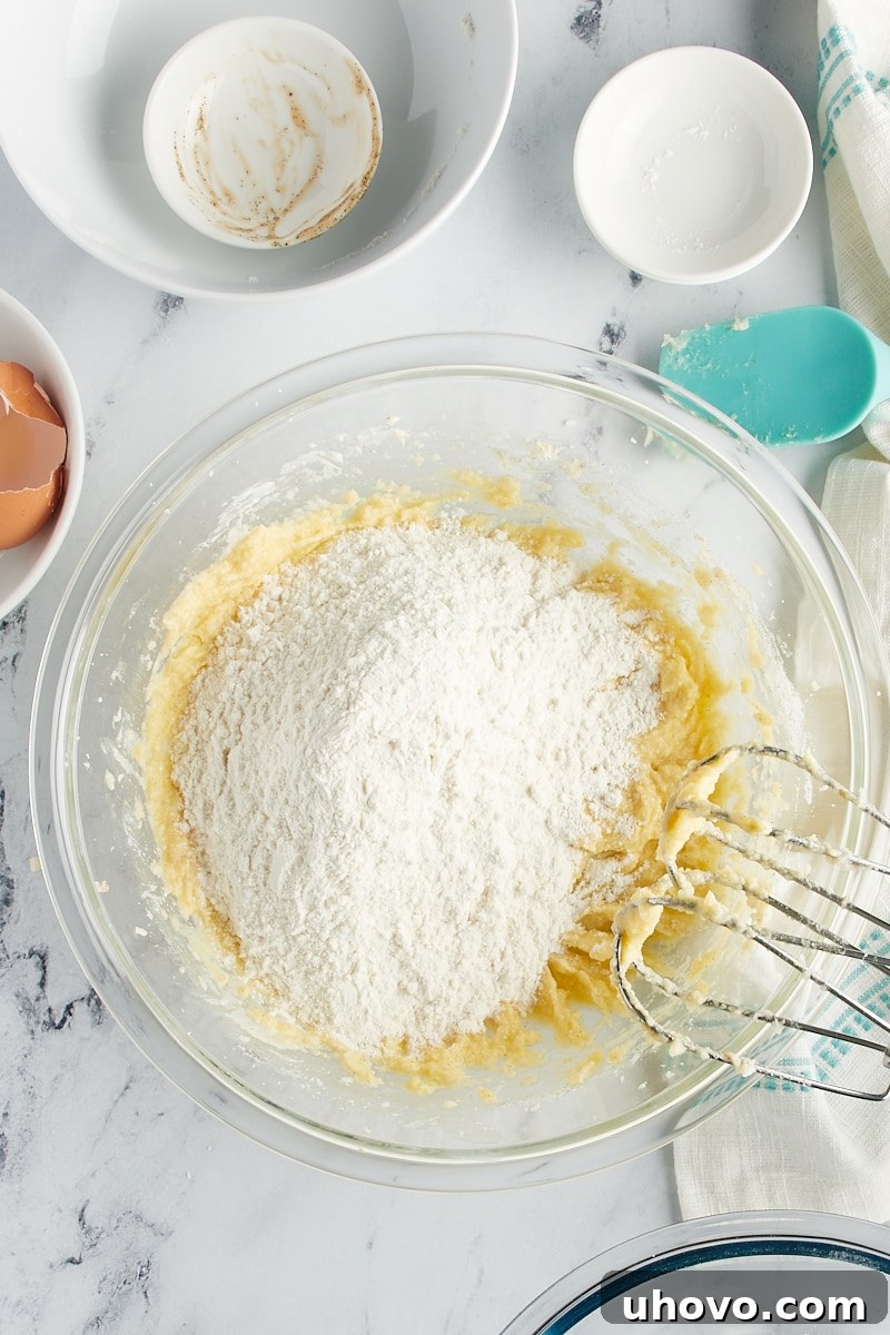 Overhead view of dry ingredients added to wet cookie ingredients.