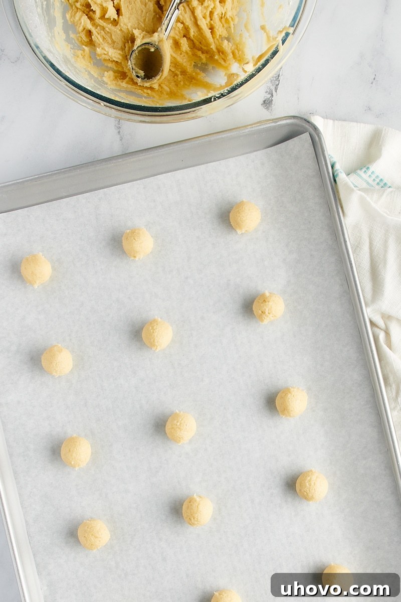 Overhead view of dough balls on a baking sheet.