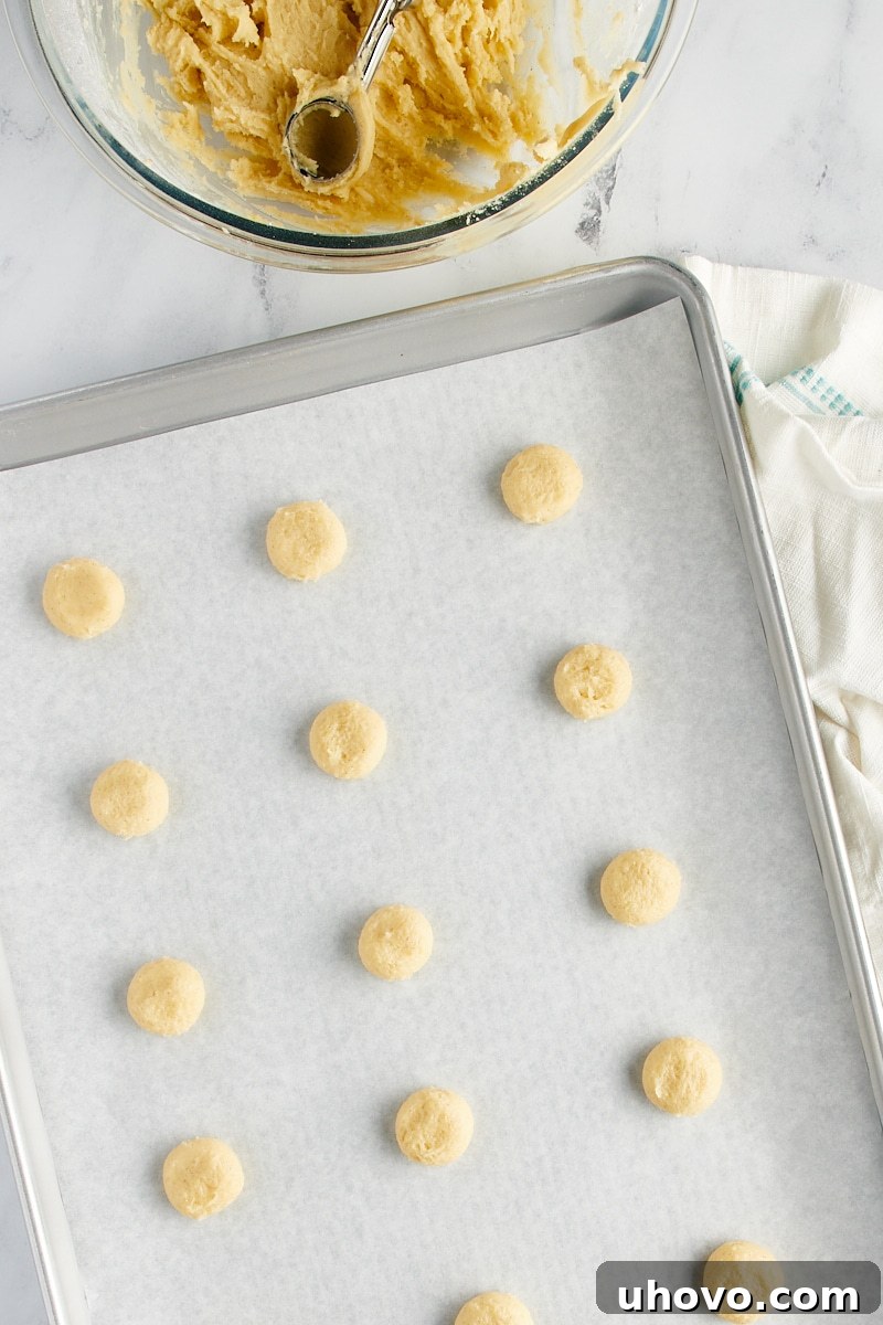 Overhead view of vanilla wafer dough on a parchment-lined baking sheet.
