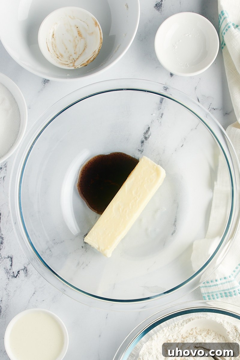 Overhead view of vanilla and a stick of butter in a bowl.