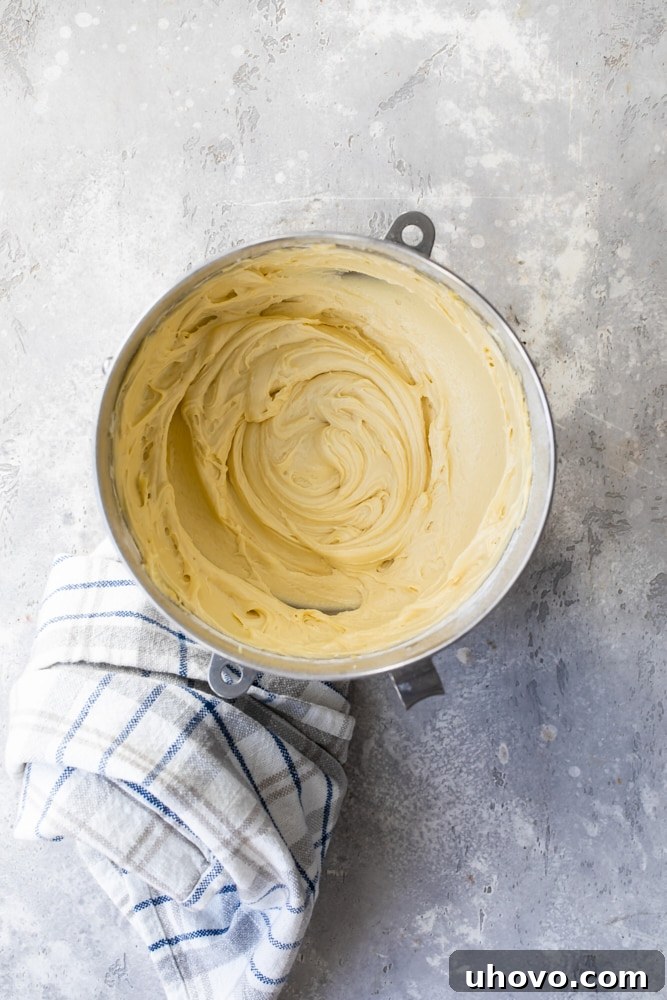 Overhead view of smoothly mixed cake batter in a mixing bowl, showcasing its readiness for the next steps.