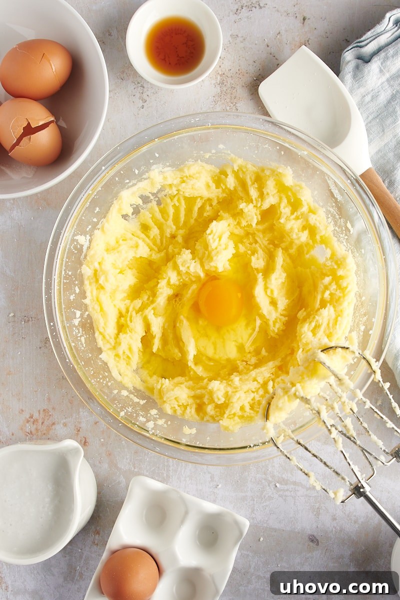 overhead view of a third egg added to the developing cake batter