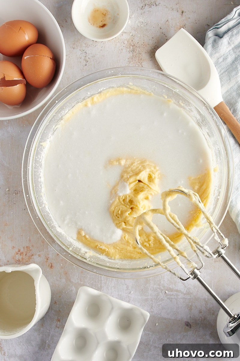 overhead view of the remaining coconut milk being poured into the cake batter