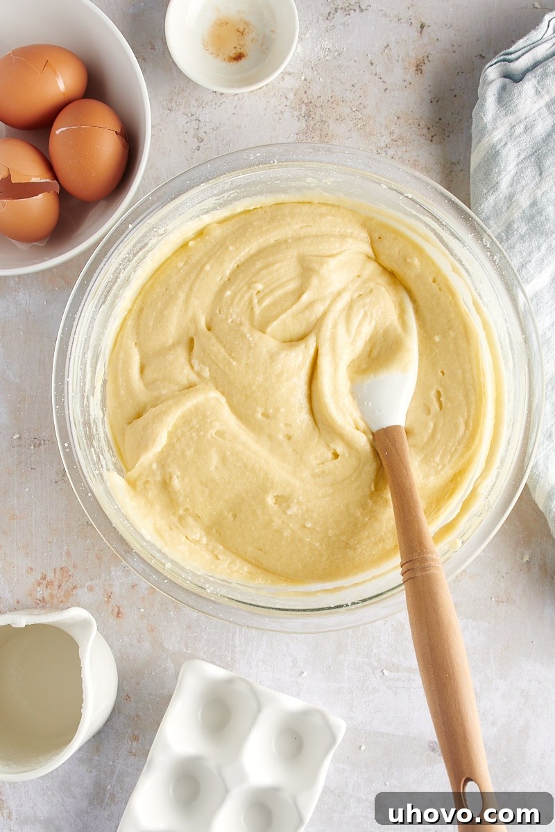 overhead view of the thoroughly mixed coconut cake batter in a glass mixing bowl