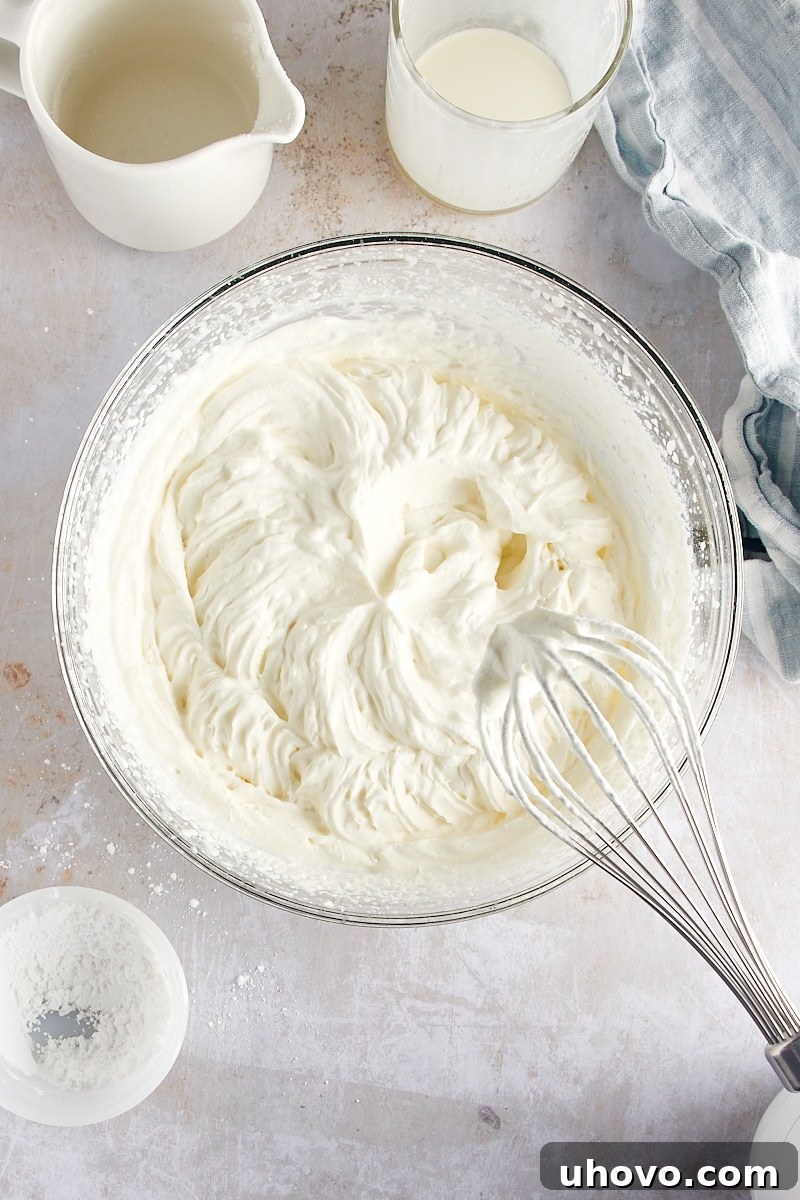 overhead view of perfectly whipped cream with stiff peaks in a glass mixing bowl