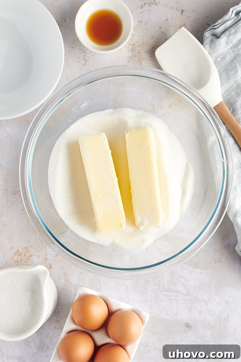 overhead view of softened butter and granulated sugar in a glass mixing bowl, creamed until light