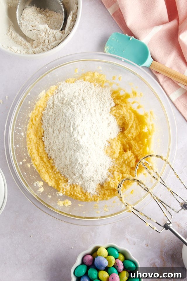 overhead view of dry ingredients gradually added to wet ingredients for M&M Marshmallow Sugar Cookie Bars