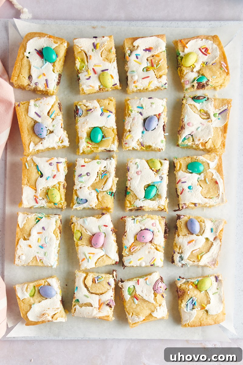 overhead view of perfectly sliced M&M Marshmallow Sugar Cookie Bars arranged on parchment paper, ready for serving
