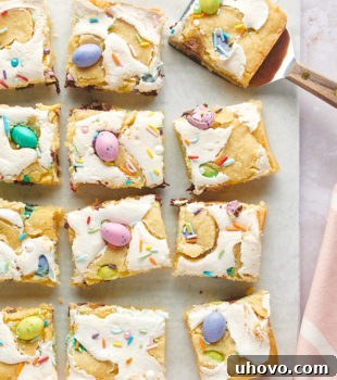 overhead view of sliced M&M Marshmallow Sugar Cookie Bars on white parchment paper