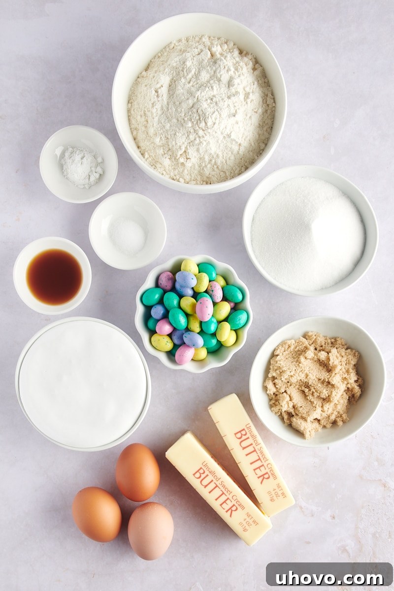 overhead view of various baking ingredients, including flour, butter, sugars, eggs, vanilla, M&Ms, and marshmallow creme