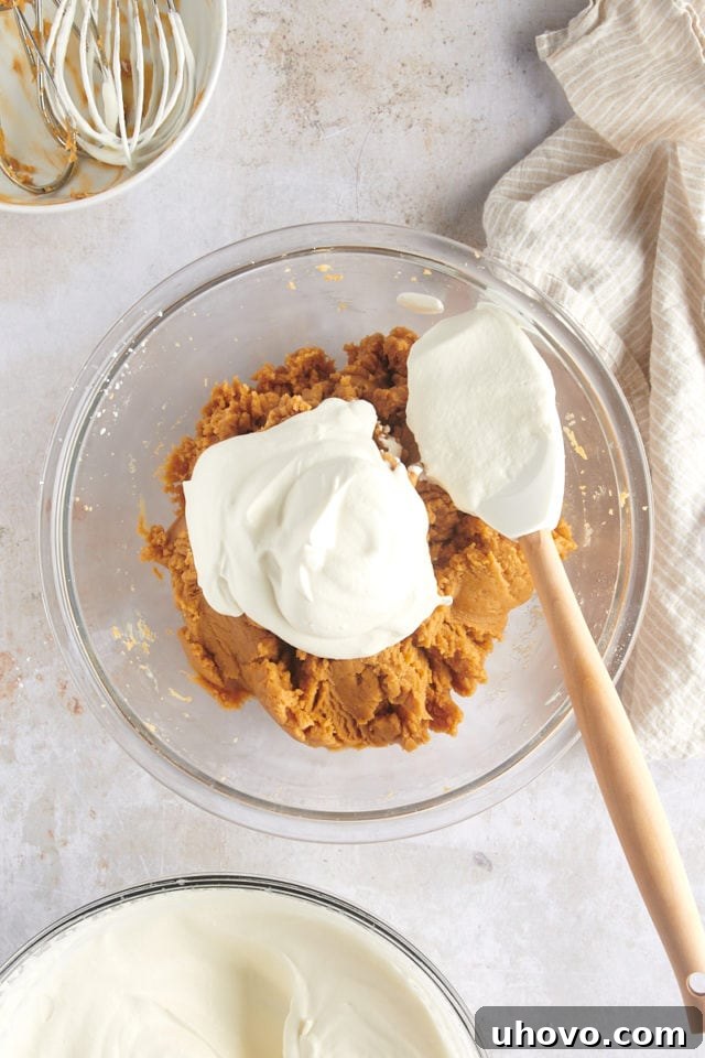 overhead view of whipped cream added to mixed cream cheese, peanut butter, and confectioners' sugar
