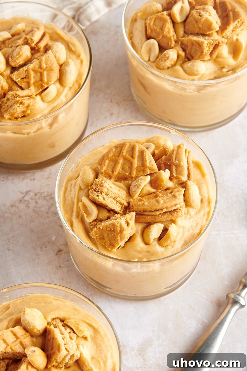 Peanut Butter Mousse served in clear glasses and topped with peanut butter cookies and peanuts