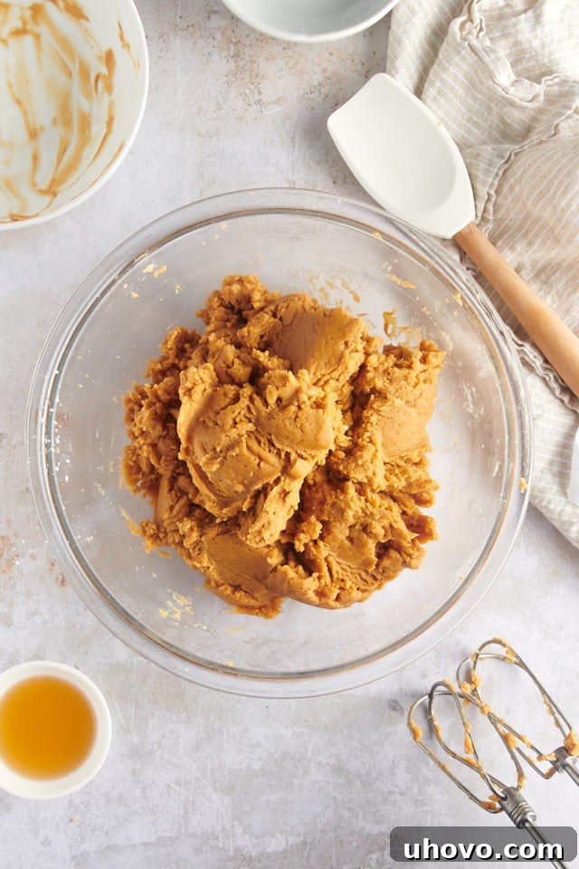 overhead view of mixed cream cheese, peanut butter, and confectioners' sugar in a glass mixing bowl