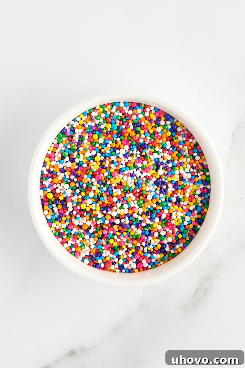 overhead view of nonpareils in a white bowl on a marble surface