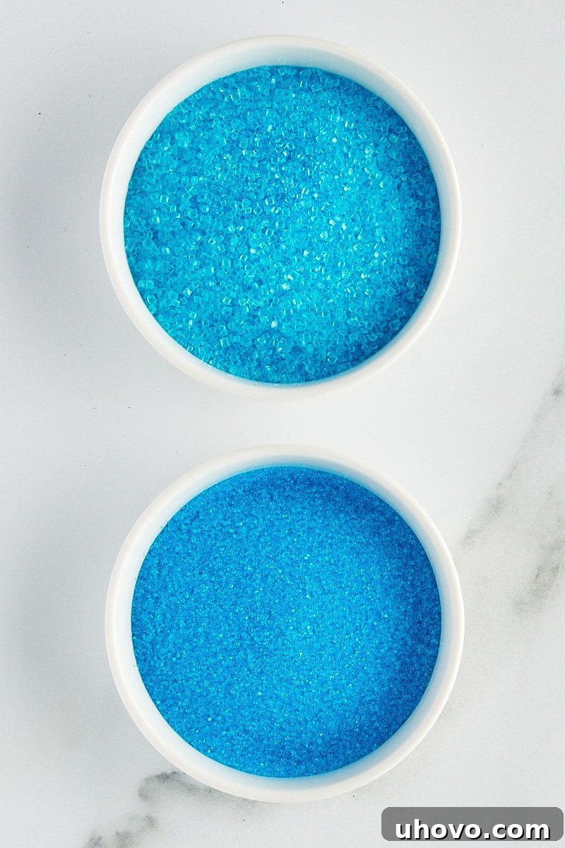 overhead view of blue sparkling sugar and sanding sugar in white bowls