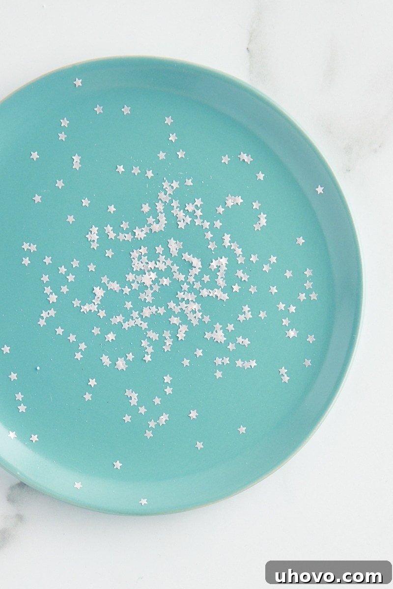 overhead view of star-shaped edible glitter on a turquoise plate