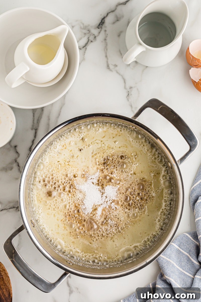 Overhead view of caramel simmering gently in a pot, after the cream has been added