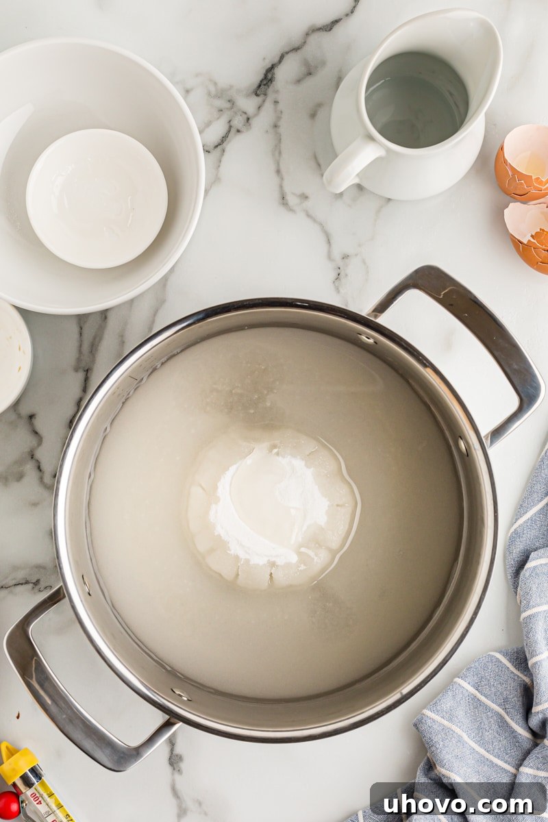 Overhead view of sugar, water, and corn syrup combined in a heavy saucepan, beginning the caramel-making process