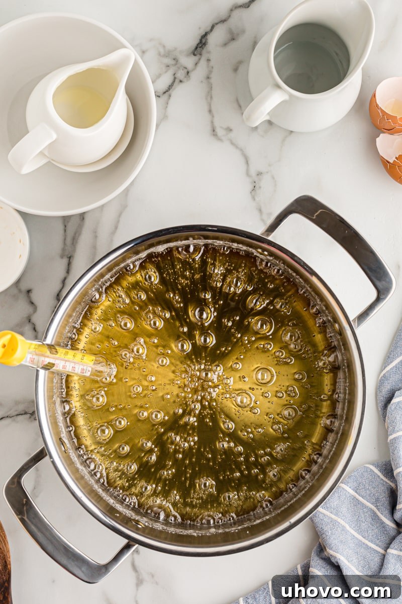 Overhead view of the sugar and water mixture boiling vigorously in a pot, transitioning into caramel