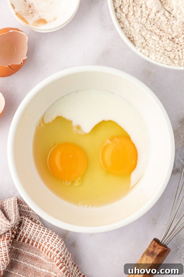 A small bowl holding two large eggs and a splash of milk, lightly whisked together, prepared to be incorporated into the brown butter snickerdoodle dough.