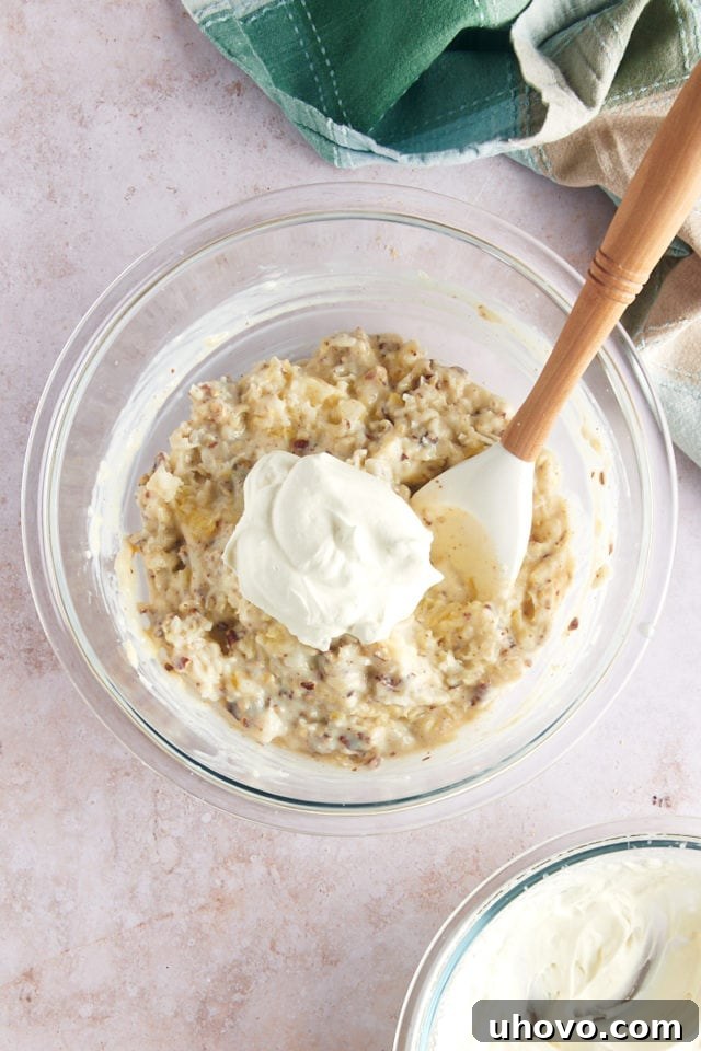 Dollop of whipped cream in mixing bowl with pie filling