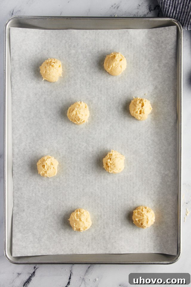 Overhead view of precisely portioned tea cake dough on a baking sheet, spaced for optimal spreading during baking.