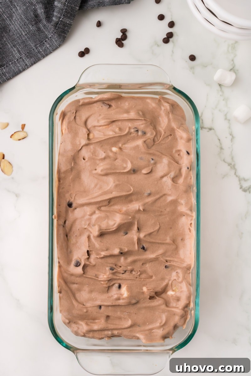 An inviting overhead view of freshly made Rocky Road ice cream neatly settled in a glass pan, showing its ready-to-scoop texture.