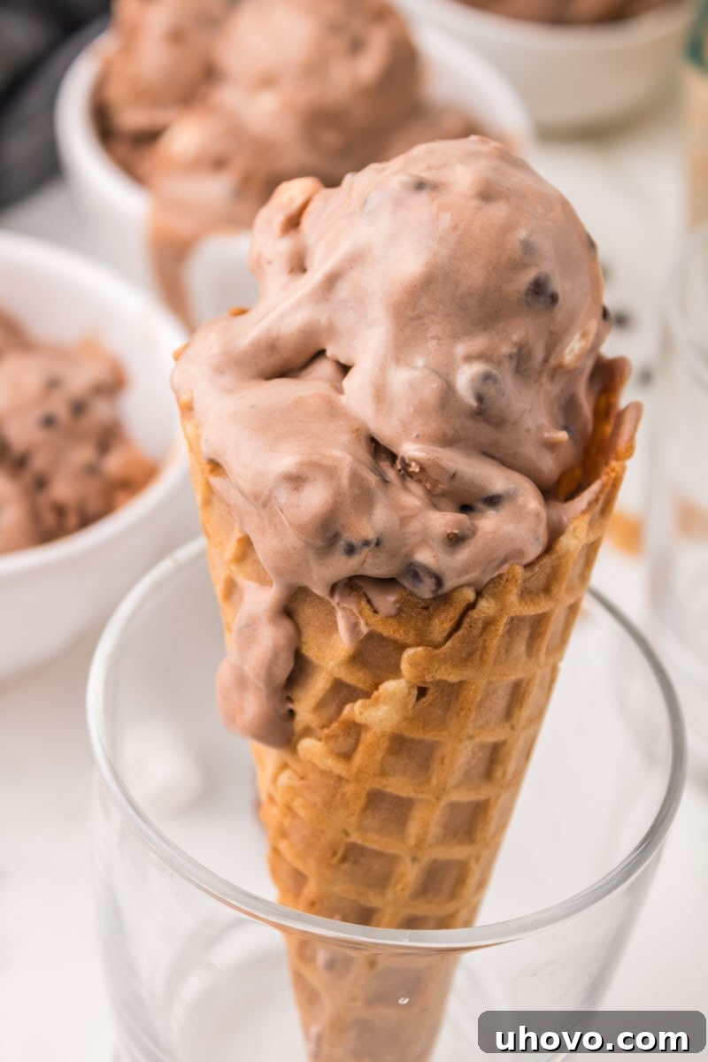 A scoop of homemade Rocky Road Ice Cream elegantly served on a crispy waffle cone, highlighting its rich textures and inviting presentation.