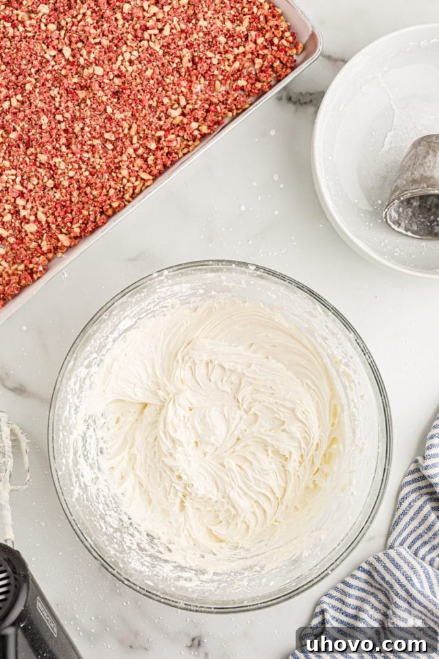 Overhead view of fluffy, smooth cream cheese frosting in a mixing bowl, ready to be used on the cake.