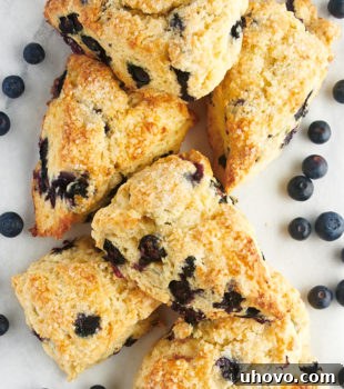 overhead view of blueberry scones and blueberries on a white surface