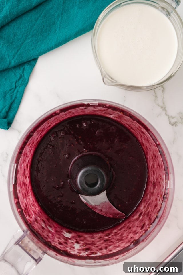 overhead view of smooth blackberry puree in the bowl of a food processor