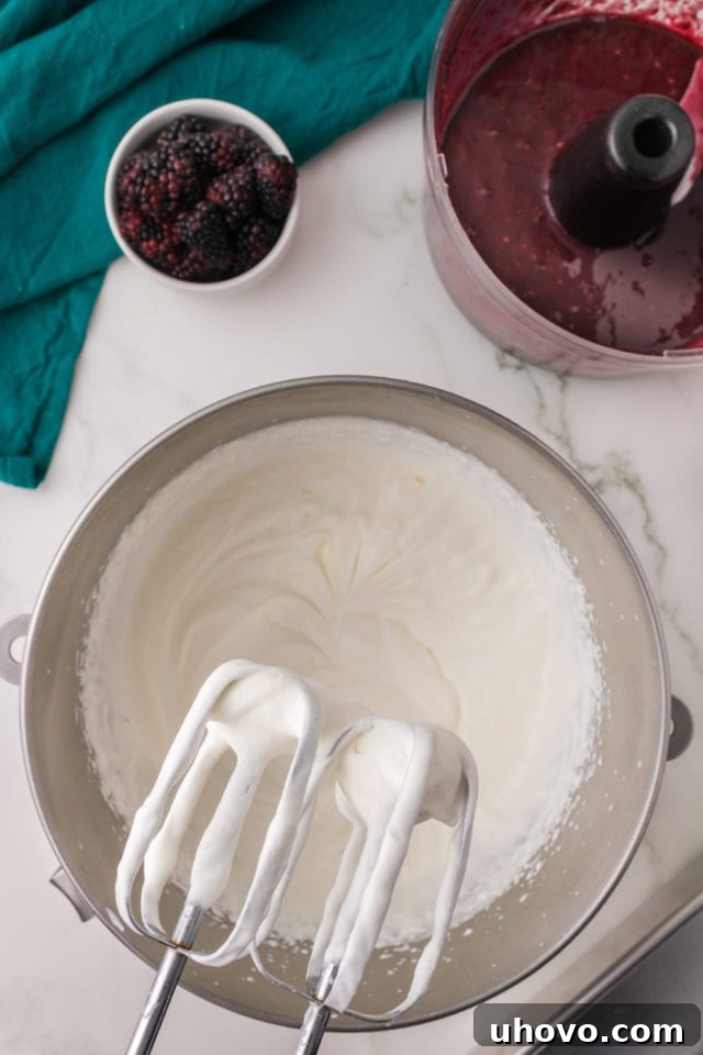 overhead view of partially whipped heavy cream in a cold metal mixing bowl