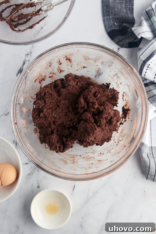 overhead view of mixed chocolate wafer cookie dough in a glass mixing bowl