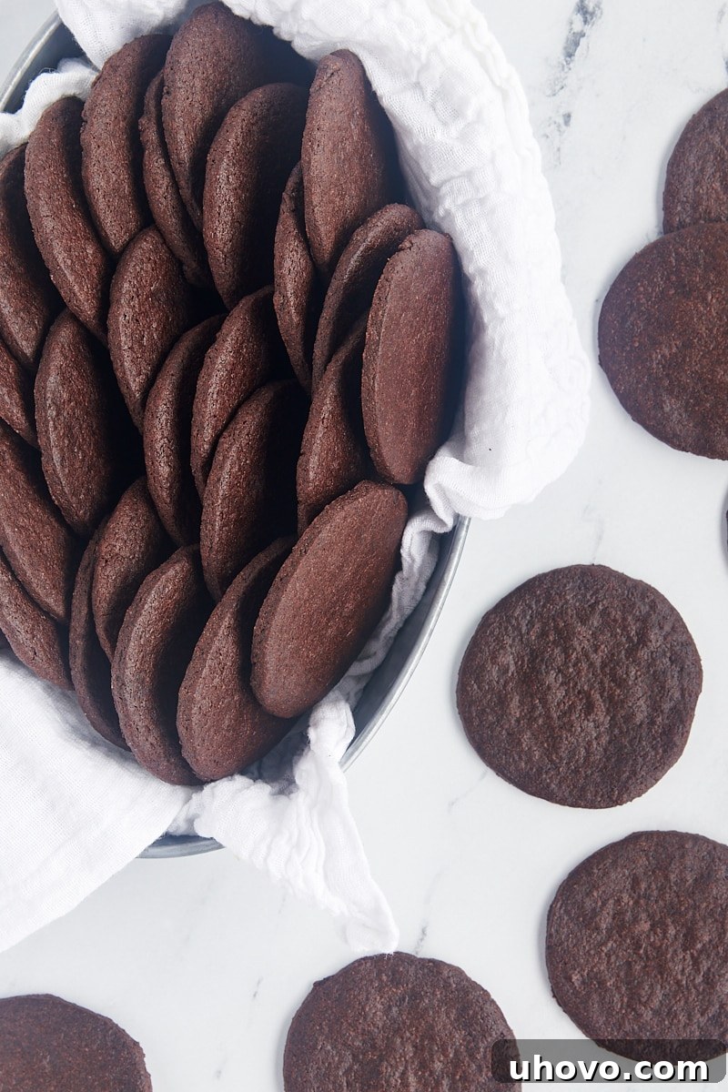 overhead view of chocolate wafer cookies in a towel-lined basket with more cookies alongside