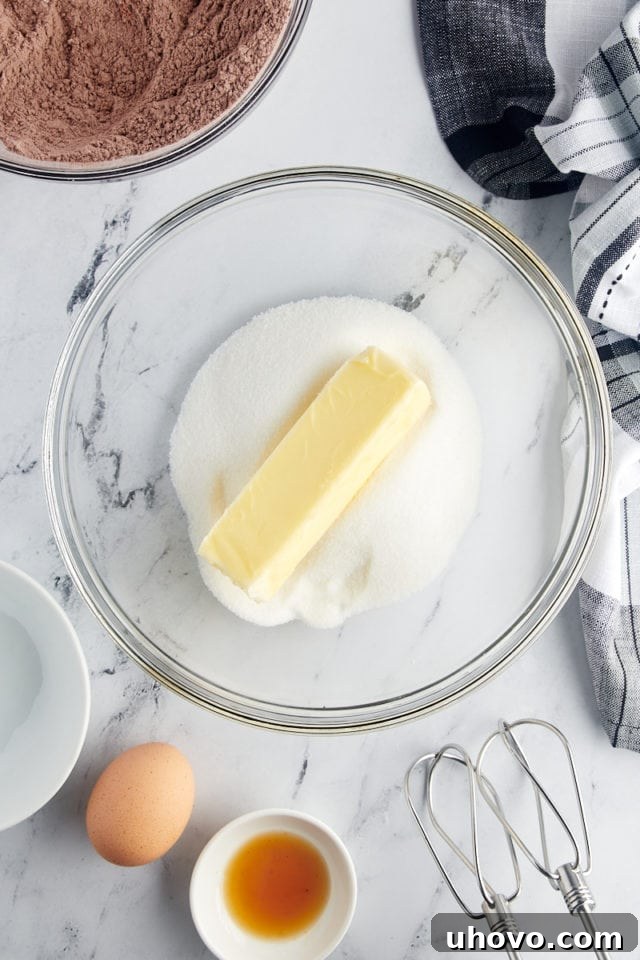 overhead view of sugar and butter in a glass mixing bowl