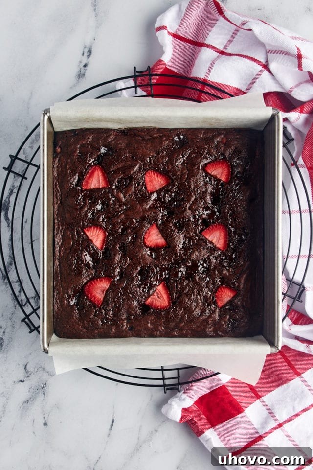 Overhead view of strawberry brownies in the baking pan, resting on a wire cooling rack straight out of the oven.