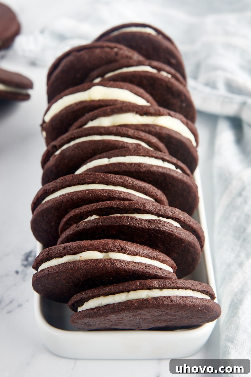 Homemade Oreo cookies beautifully arranged in a narrow white tray, showcasing their perfect dark chocolate color and creamy white filling.