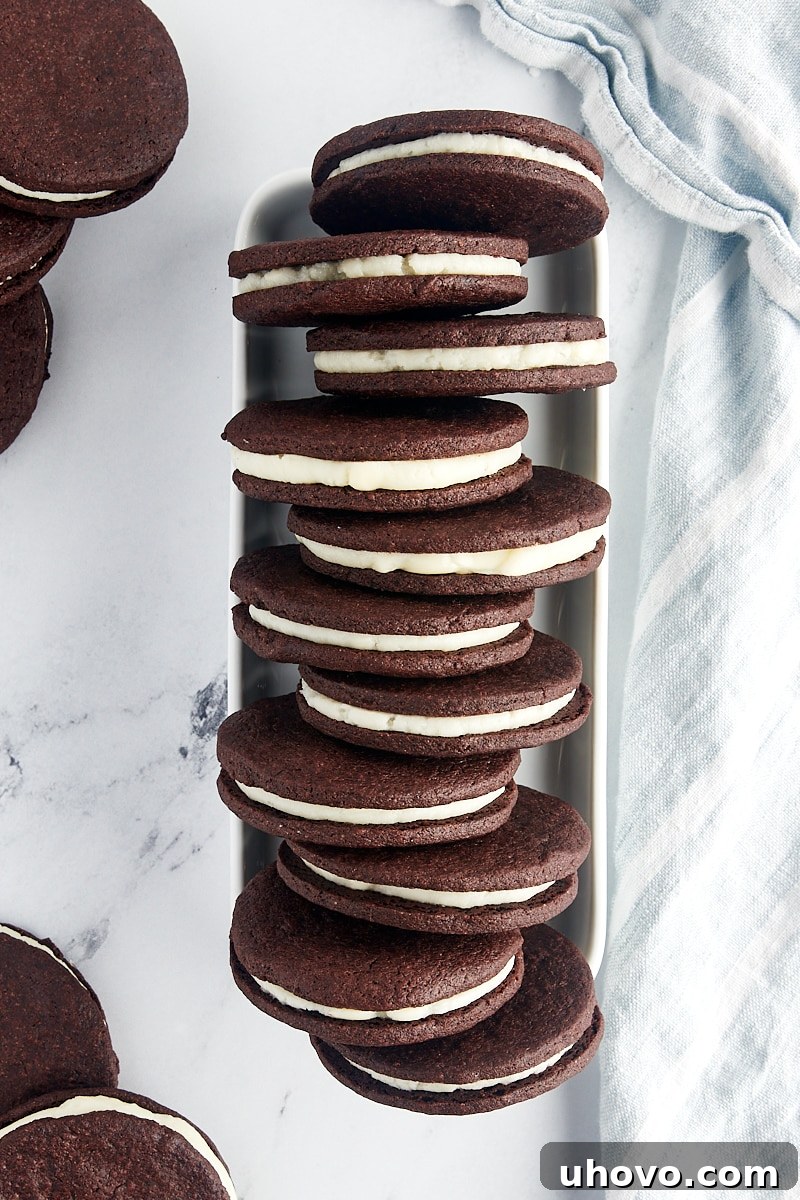 An inviting overhead view of a row of homemade Oreos, neatly lined up in a narrow white tray, emphasizing their consistent size and appealing appearance.