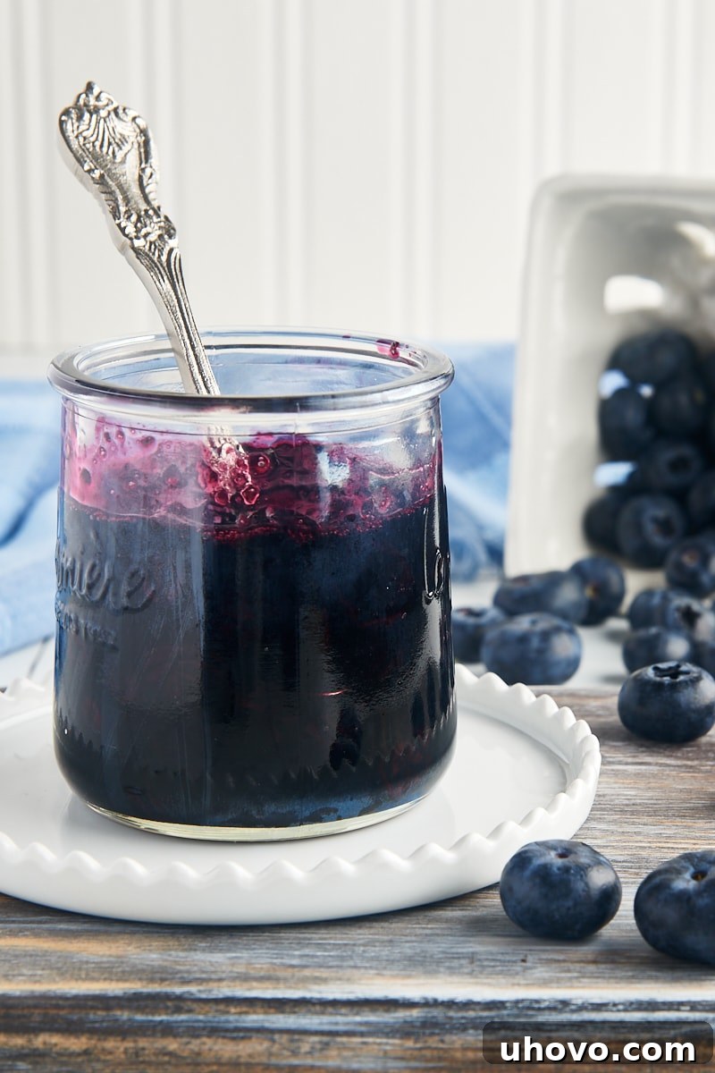 A beautifully clear glass jar filled with homemade blueberry compote, ready for storage or serving.