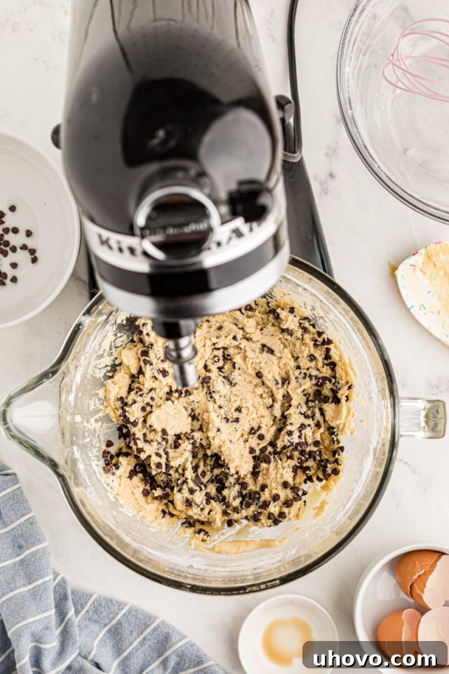 overhead view of chocolate chip cookie dough in a glass mixing bowl