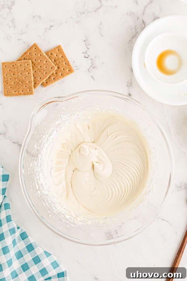 Overhead view of heavy cream being whipped to firm peaks in a separate mixing bowl.