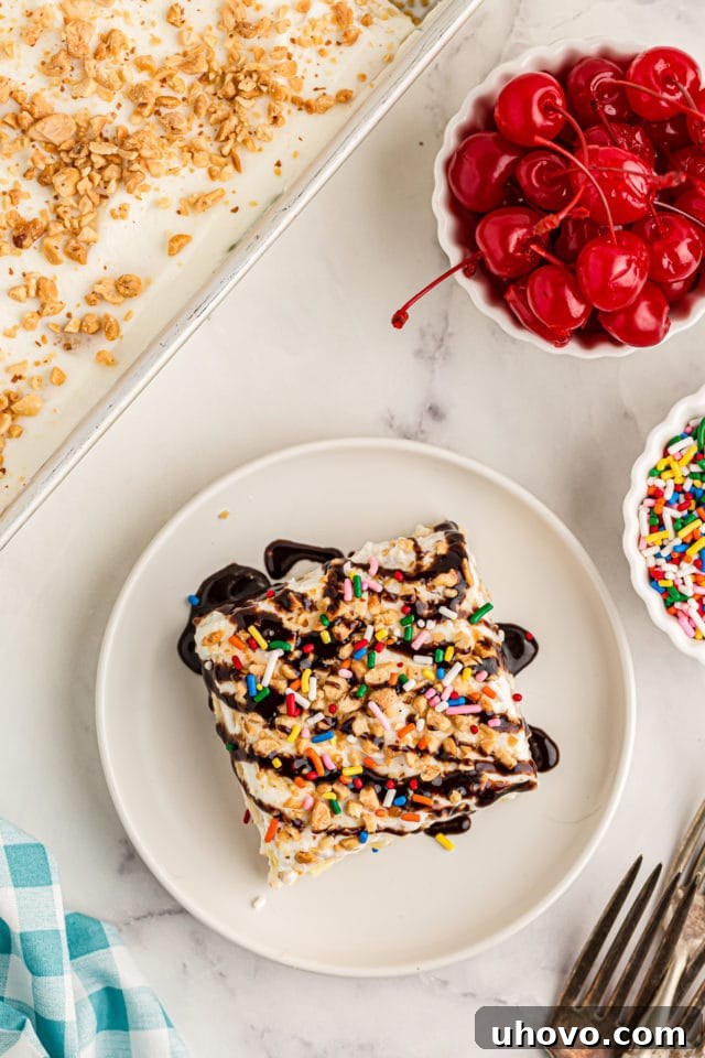 Overhead view of multiple slices of banana split cake on plates, garnished, surrounded by sundae toppings.