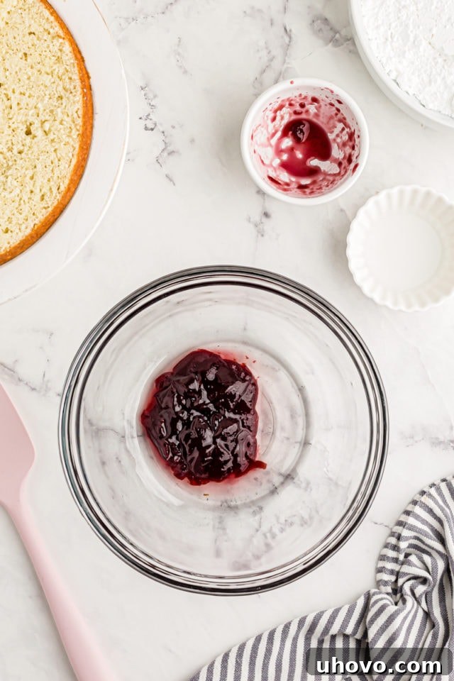 Overhead view of raspberry jam and water in glass bowl