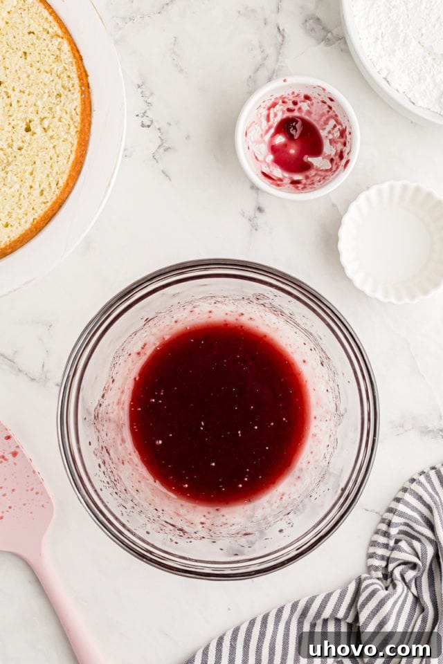 Overhead view of raspberry jam mixture in glass bowl