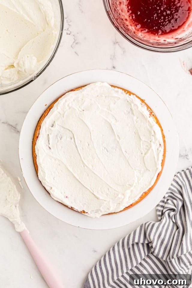 Overhead view of frosting added to layer of cake