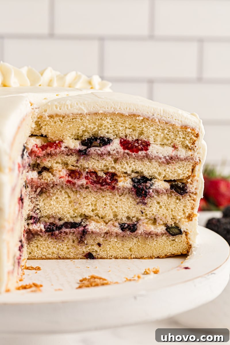 Chantilly cake on cake stand with slices removed to show layers