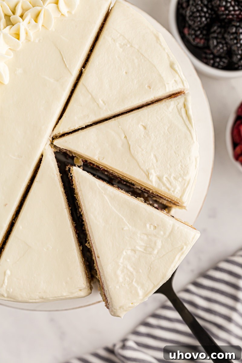 Overhead view of sliced chantilly cake with slice being removed